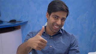 Portrait of happy Indian man giving thumbs up and smiling in dentist / doctor studio
