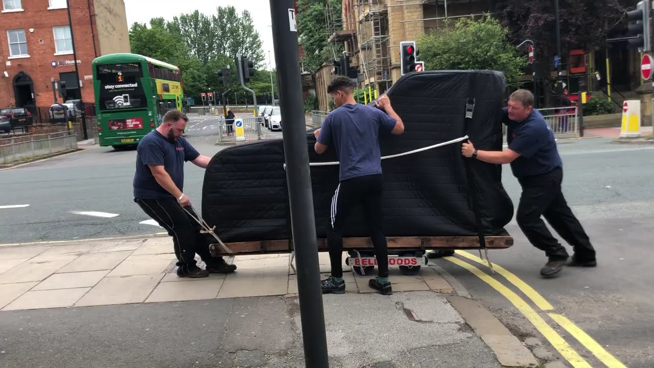 Yorkshire Piano Logistics team moving a 9ft Steinway concert grand piano through the streets of Leeds