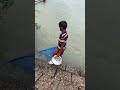 A little boy catching small fish with a net from the river—pure innocence, pure village life! 🐟