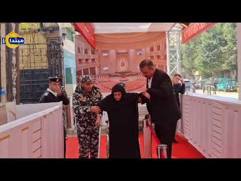 رجال الأمن يساعدون مسنة على الإدلاء بصوتها في مدرسة أنصاف سري بحلمية الزيتون