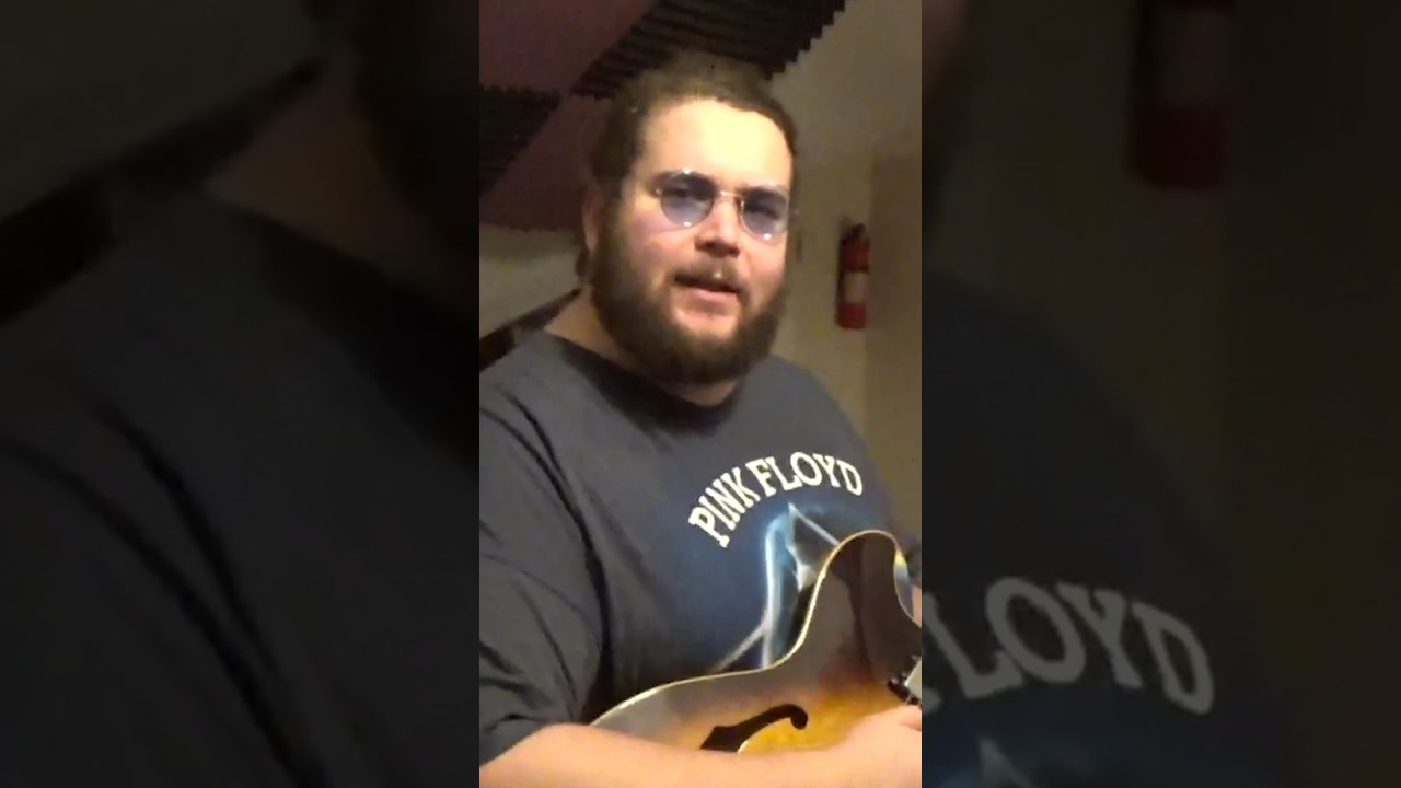 Guitar Center manager reviews a vintage hollow body guitar 