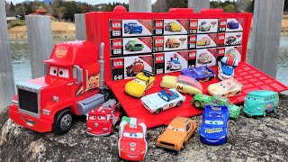 A big red trailer loaded with boxes collects the miniature car