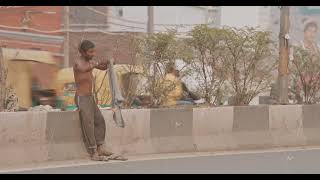 New Delhi, Delhi, India. Indian Man Changes Clothes On The Street. Traffic On The Desh Bandhu Gupta