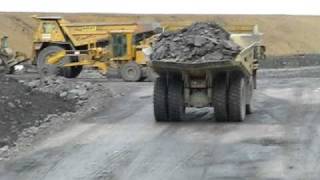 cat 777 and komatsu HD785 going under the bridge with a 16H grader working on the haul road