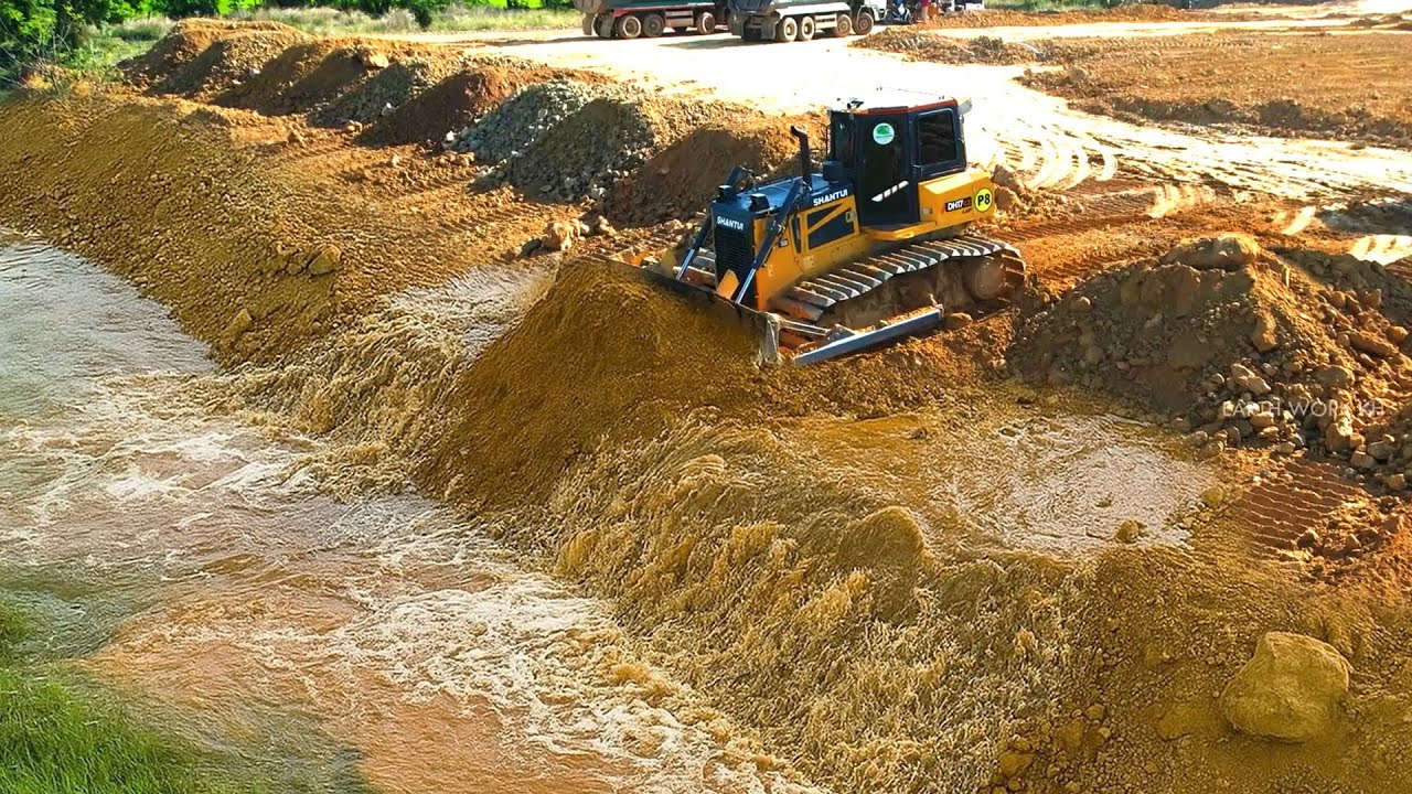 Perfectly Machine Bulldozer pushing soil landfilling up filling into the big pond & clearing mud