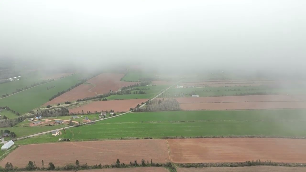 Drone ascending through low cloud layer, PEI, Canada