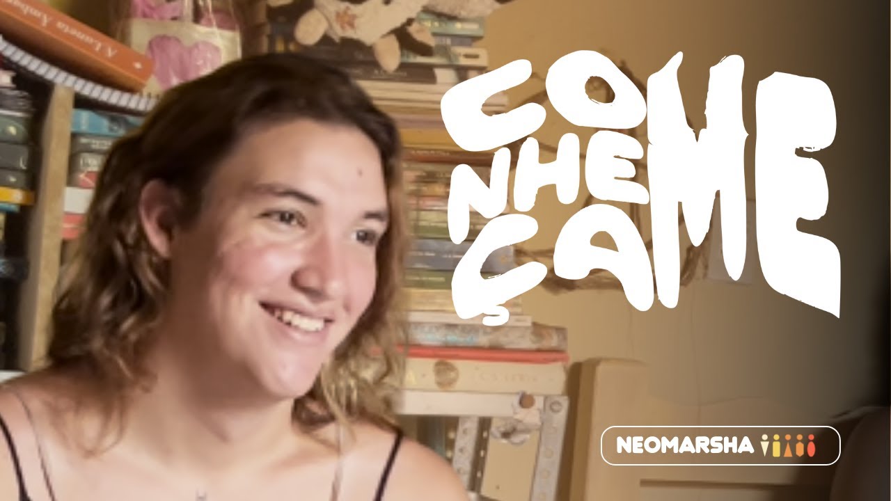Captura de tela de um vídeo de Diana Berreto, uma mulher trans jovem com pele branca e cabelo castanho-claro e ondulado, sorrindo. Ela usa uma blusa de alças pretas. No fundo, há uma prateleira com livros e decorações. A imagem tem sobreposta a palavra "CONHEÇA-ME" em letras brancas e estilizadas. No canto inferior direito, há uma caixa de texto que diz "NEOMARSHA", com um ícone de figuras humanas ao lado.