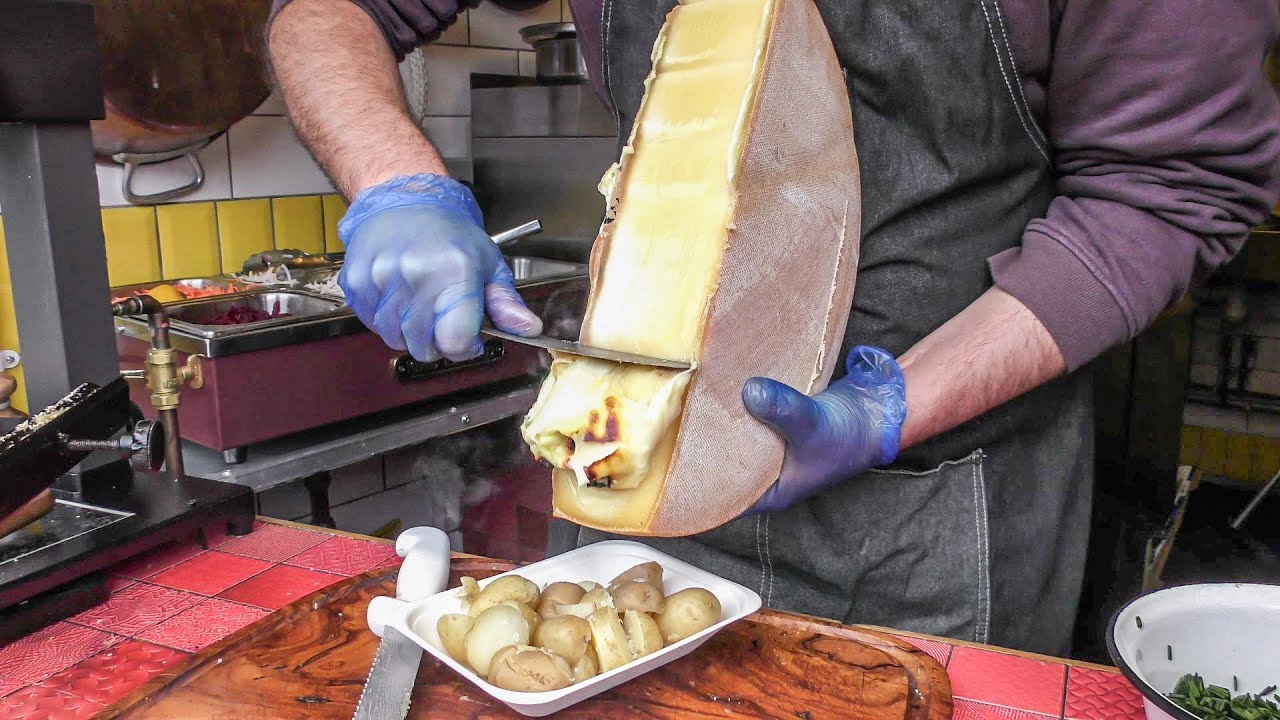 Yummy Swiss Raclette. Warm Melted Swiss Cheese with Egg and Potatoes. London Street Food