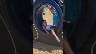 Boy spins his brother on hamster wheel at amusement park then he falls forward and faceplants