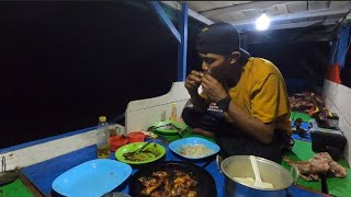 Mancing masak dan makan udang panggang di perahu di malam hari  
