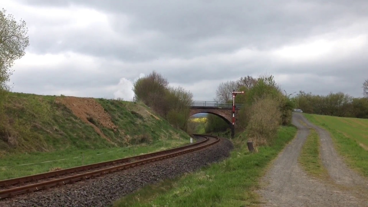 52 4867 verlässt Niederzeuzheim auf der Oberwesterwaldbahn, am Zugschluss hängt 215 086.
