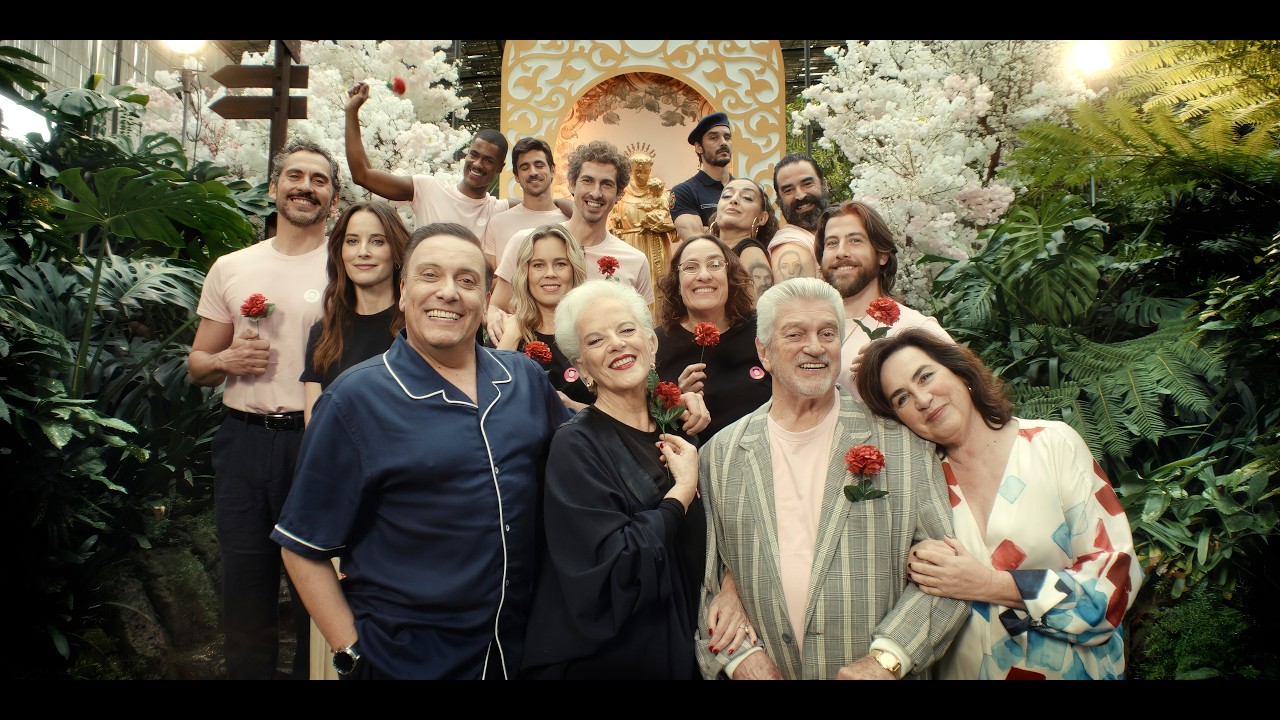 The cast of Santo António – O Casamenteiro de Lisboa gathered around the saint's statue, red carnations in hand