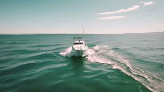 a white boat navigating through the vast expanse of the open ocean, Aerial