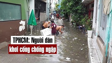 TP.HCM mưa liên tục, người dân khơi cống chống ngập - PLO
