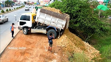 Opening New project landfill flooded deep by dump truck unloading soil and bulldozer D31P pushing