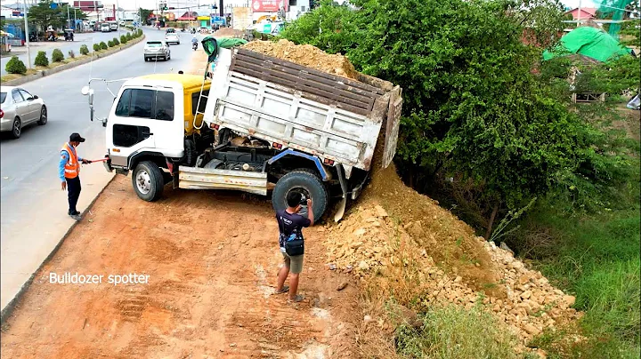 Opening New project landfill flooded deep by dump truck unloading soil and bulldozer D31P pushing
