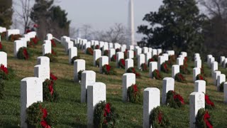 Volunteers lay wreaths at Arlington National Cemetery to honor veterans