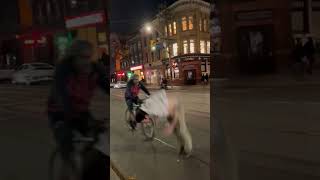 Guy does backflip from pole on sidewalk and lands on guy riding bike on street