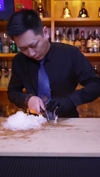 BB Bartender cuts diamond ice with hand cubes to make a cup of mellow and elegant cocktail