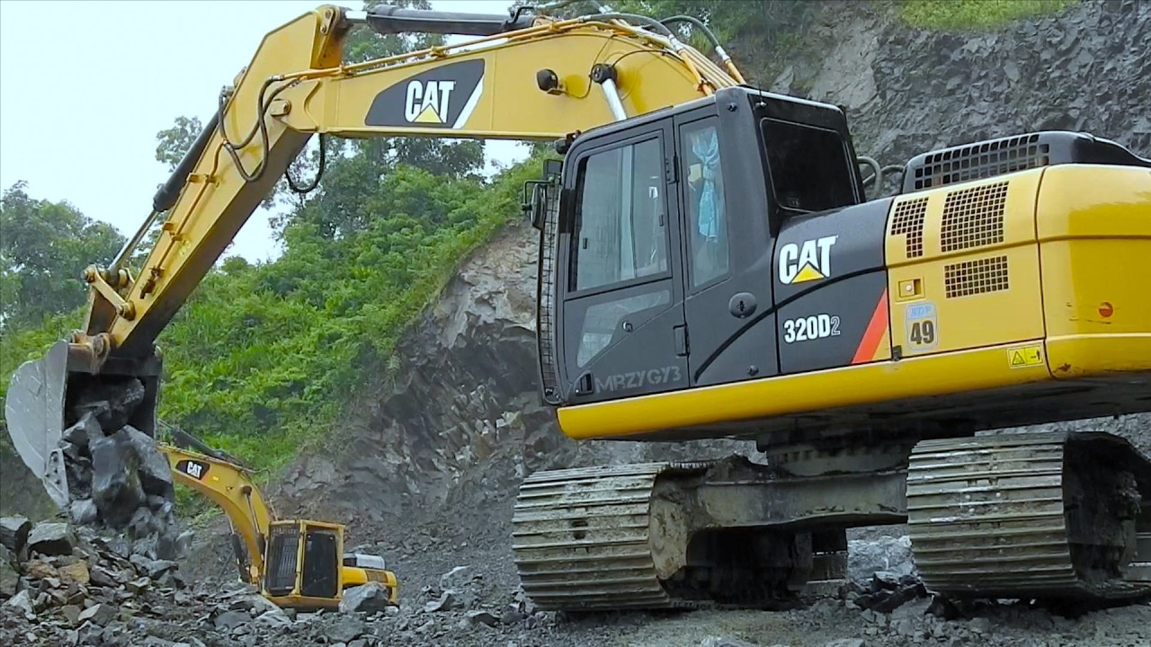CAT Excavator Digging And Dropping Rocks From The Hilltop