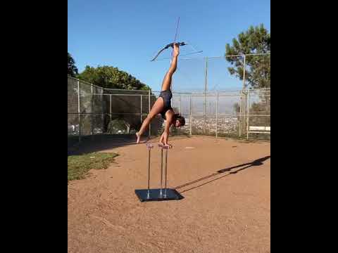 Woman Does Handstand and Shoots Bow Shot via Toes - 1131175
