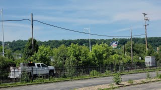 CSX High-Rail Truck and a NS Manifest Train Pass Each Other in Homestead, Pennsylvania.
