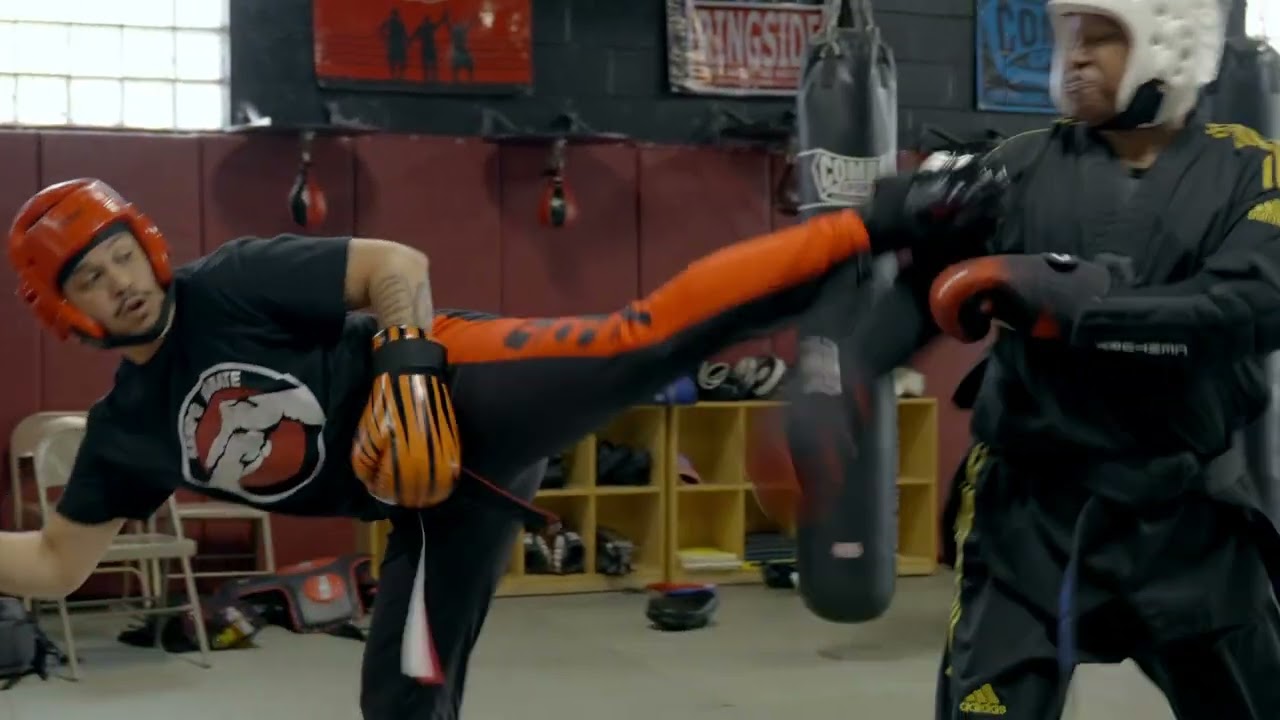 Two students sparring in orange headgear during a taekwondo class at MPower Gym & Academy in Vandalia, Ohio