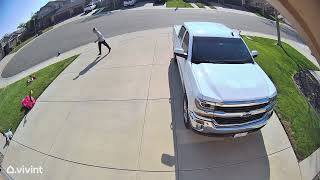 Guy kicks ball on driveway towards garage then ball hits boy on head (Security camera)