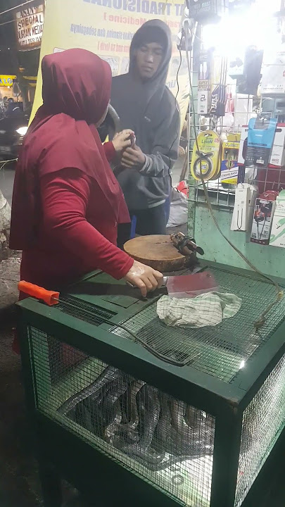 cobra snake decapitation street food in Indonesian