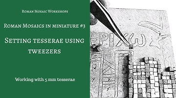 Using tweezers to set tesserae in a mosaic