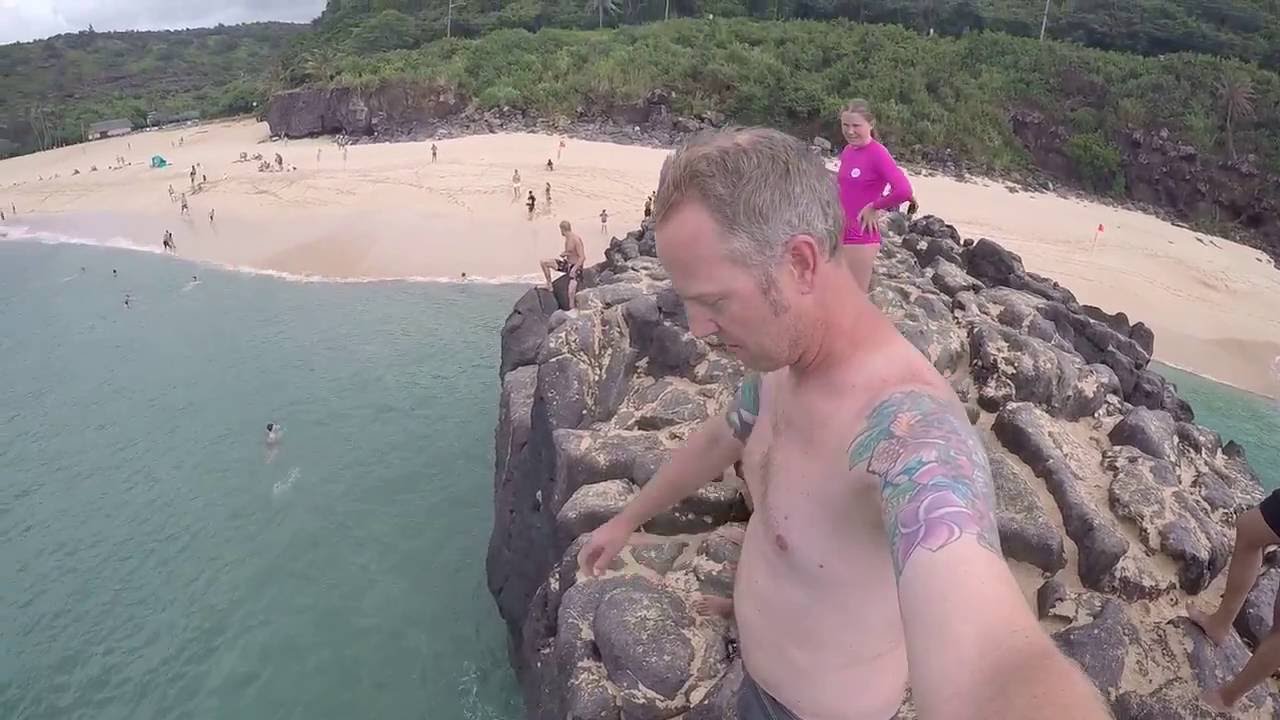Jumping off the rock at famous Waimea Beach Oahu Hawaii
