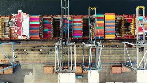 Unique and Rare Short 4K Video: Sea port, cargo ship unloading to container trucks, by giant crane