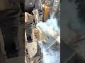 Craftsman refining curved metal blade on workshop anvil surface