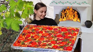 Woman сooking a giant village Pizza in a woodburning oven, so easy and delicious
