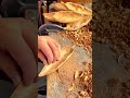 carving several small oval wooden bowls using sharp metal tool to create a smooth hollowed out shape