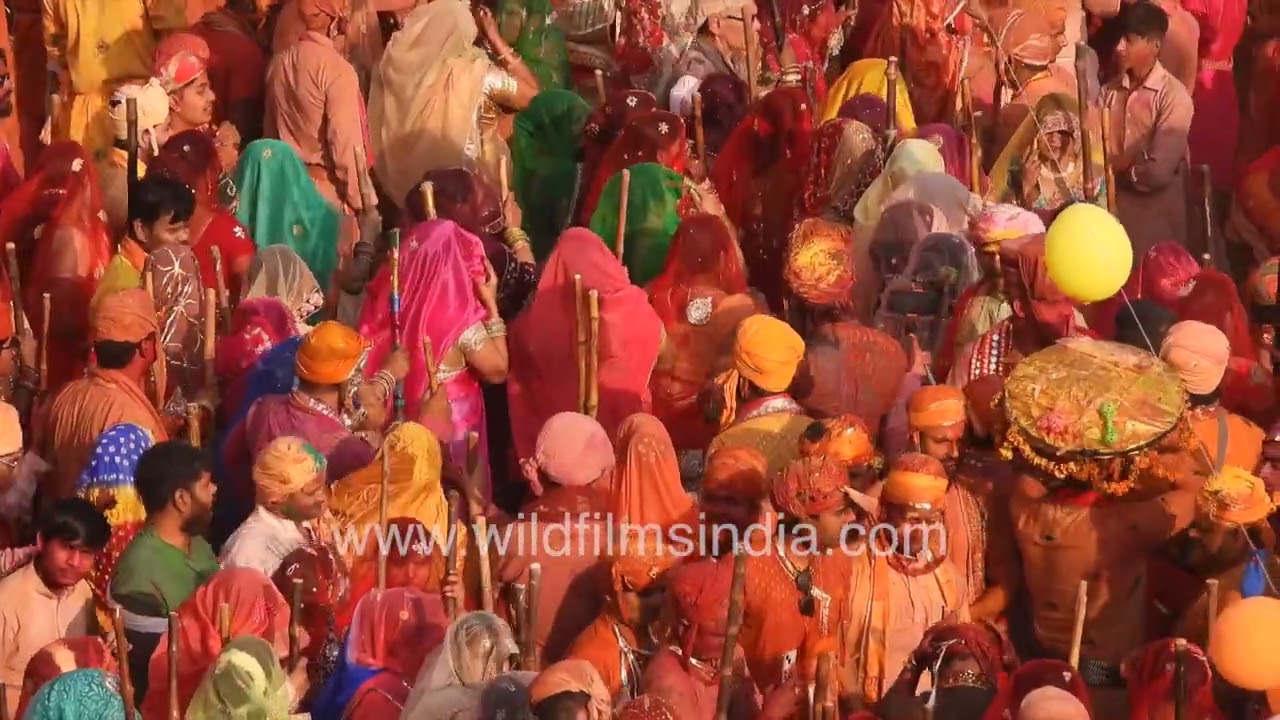 A massive gathering of Gopis and Gops fills the streets of Nandgaon during the Holi celebration