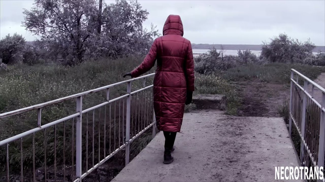 Post-apocalyptic evening walks in a black panoramic gas mask and an elongated red shiny down jacket