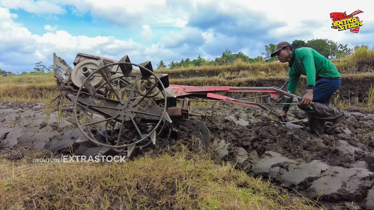 Тяжелая работа молодого водителя ручного трактора, возделывающего жесткую почву без воды