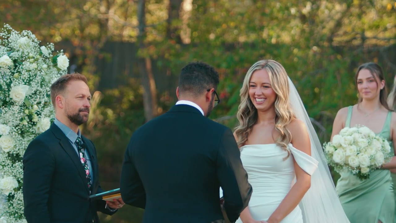 Couple sharing vows at an outdoor ceremony framed by white flowers at Sweet Meadow Farms in Tallapoosa, GA