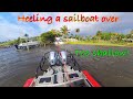 Sailboat blown into seawall. Shallow under it so I decided to heel it so I could come straight off.
