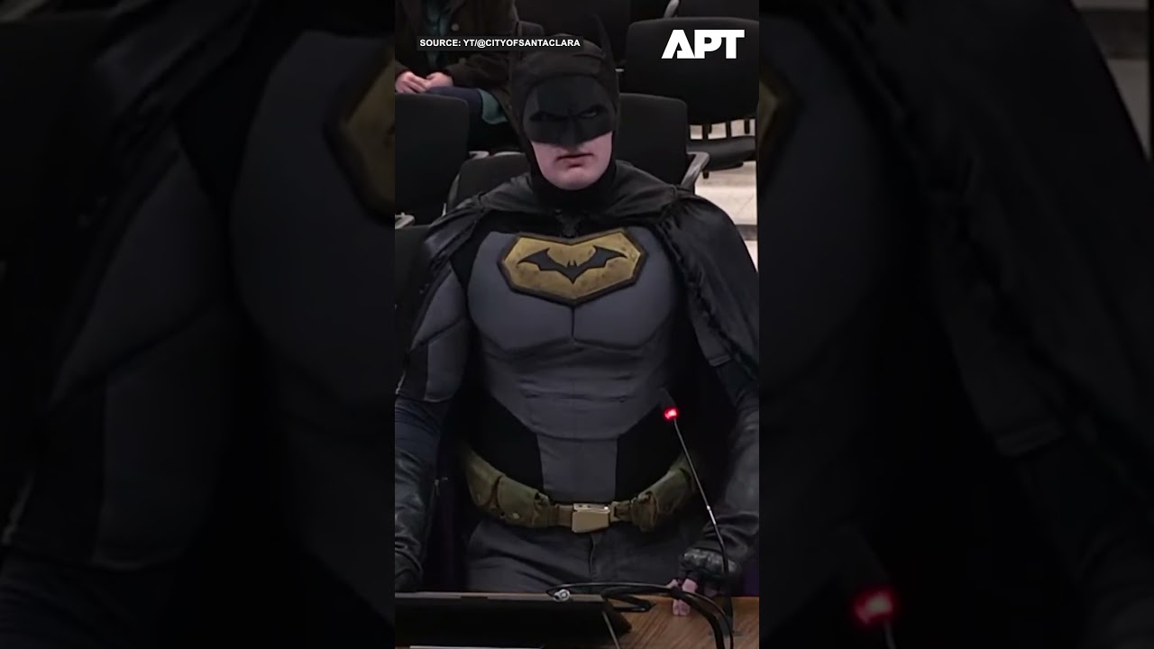 Мужчина в костюме Бэтмена противостоит лидерам Санта-Клары во время публичного собрания по сотруд...