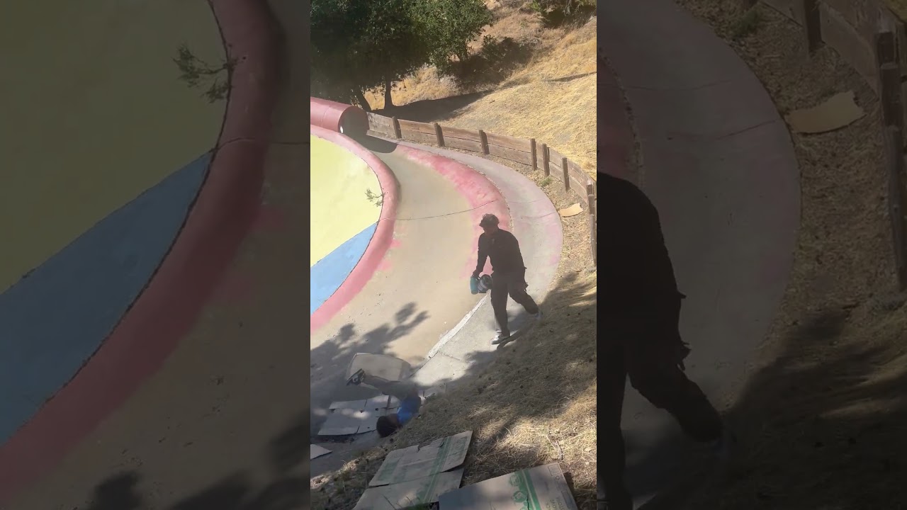 Boy rides sled down tubed slide then flips backwards and bumps head at playground