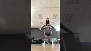 Girl lifts herself on guys shoulders and falls on her rear