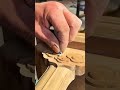 carving beautiful traditional flower patterns on wood and smoothing the details with precision
