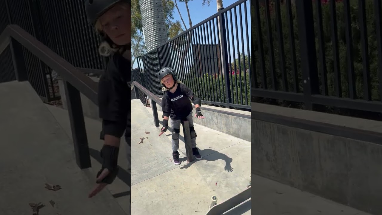 Boy on skateboard does boardslide at skatepark and lands on sensitive area on rail (Slow motion)