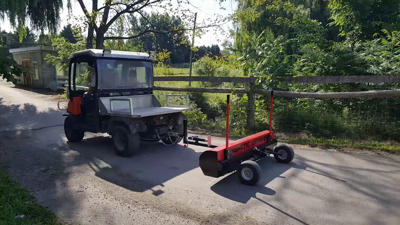 Picking up metal debris around farm with UTV magnetic sweeper yacare by bluestreak equipment