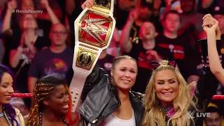 Ronda Rousey locks Stephanie McMahon in an Armbar with other female wrestlers around the ring.
