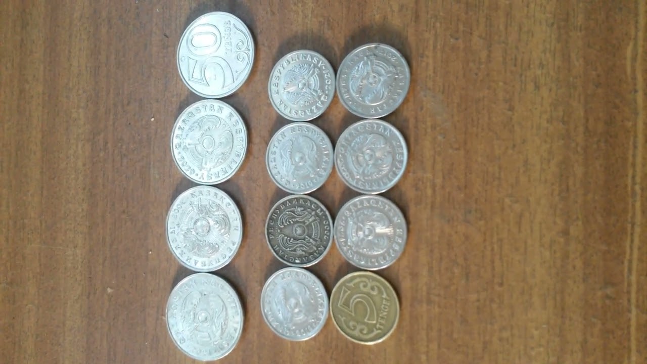 МОНЕТЫ 4 по 50, 7 по 20 и 1 по 5 ТЕНГЕ лежат на светло-коричневой поверхности Пятнадцатого Сентября