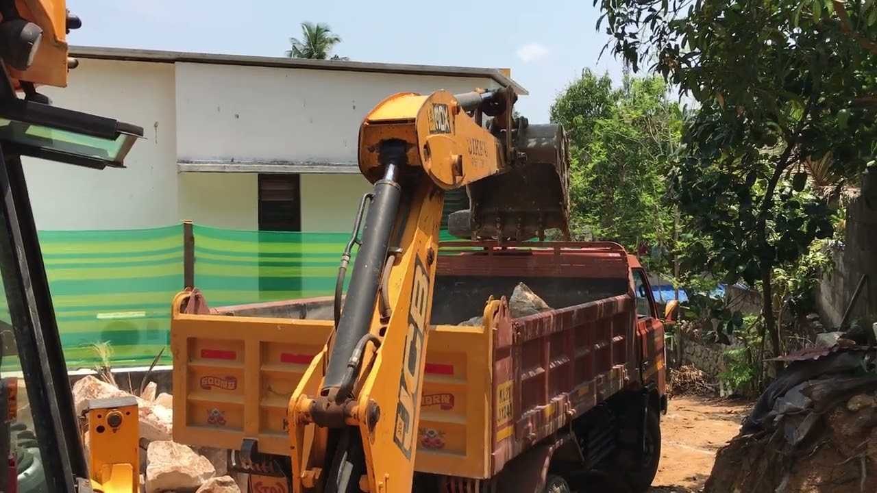 Jcb 3dx loading rock pieces into truck