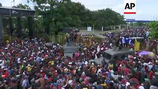 Migrants force through fence as they try to cross border into Mexico